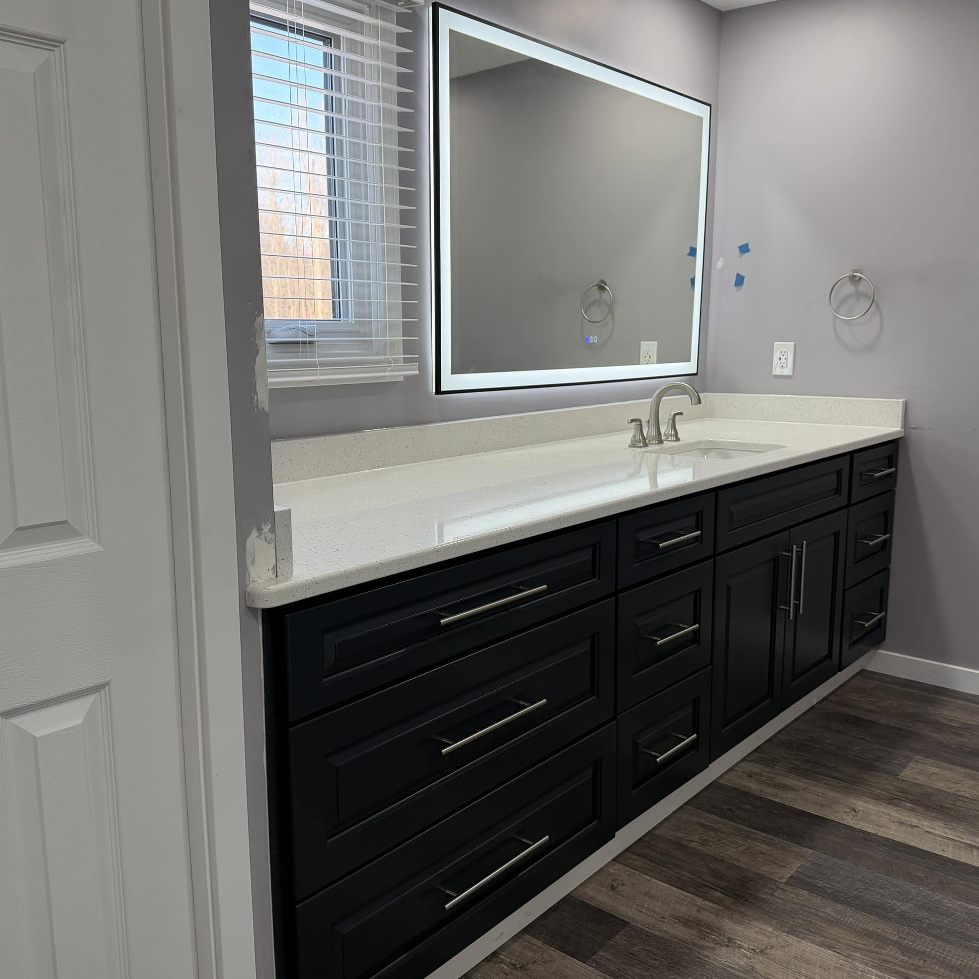 Remodeled bathroom vanity with illuminated mirror