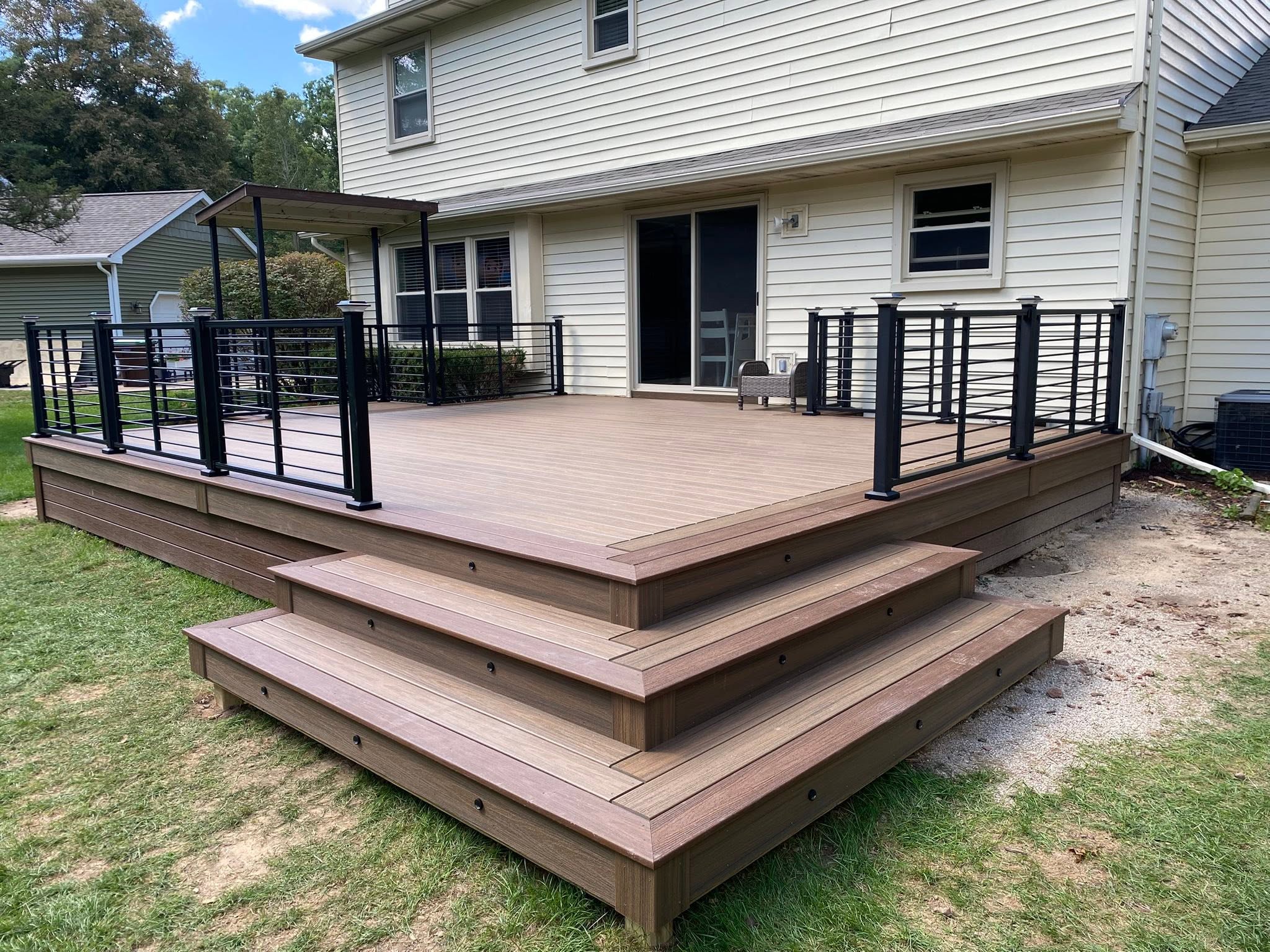 Large finished composite deck with broad stairs and metal railing